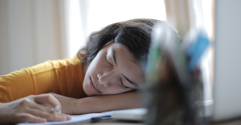  Tired woman rubbing her eyes, a common sign of adrenal fatigue symptoms